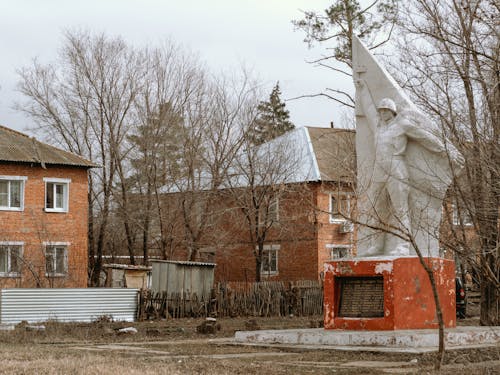 A statue of a man in front of a house