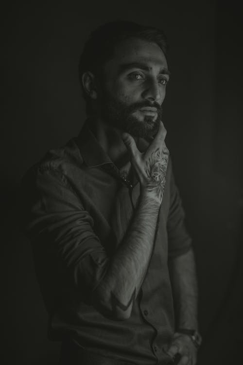 A man with beard and shirt on in black and white