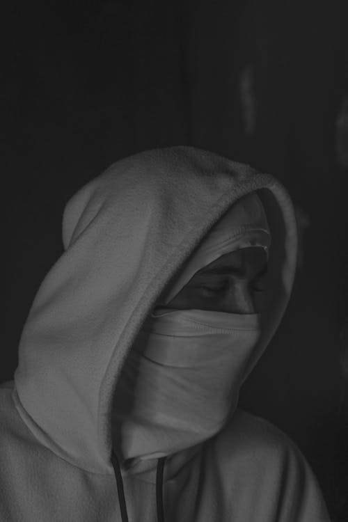 A person wearing a hoodie and a face mask