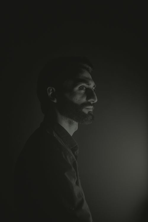 Free Dark and moody profile portrait of a man with facial hair, evoking a mysterious atmosphere. Stock Photo