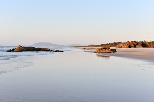 A beach with a sandy shore and rocks