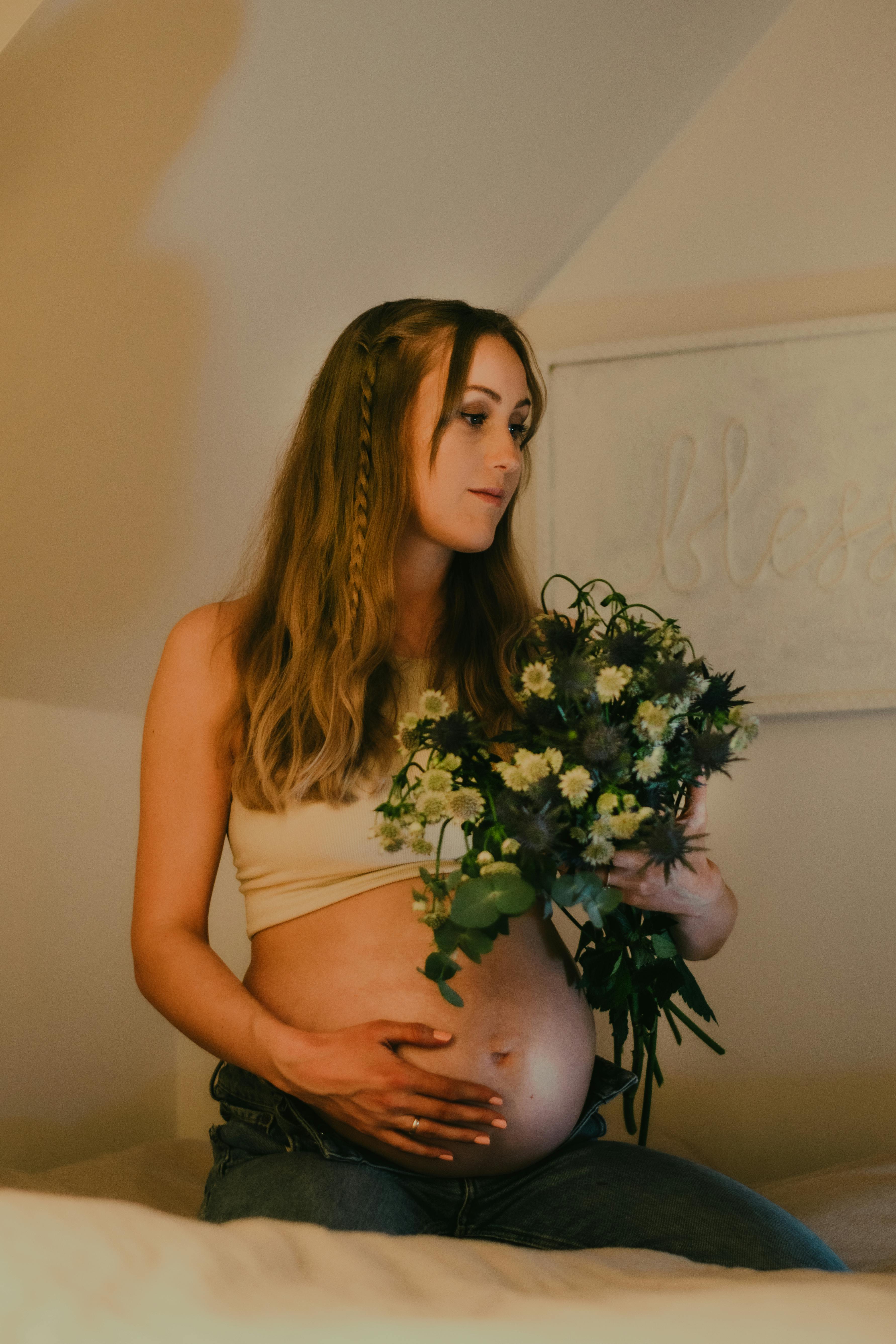 pregnant woman holding bouquet of flowers