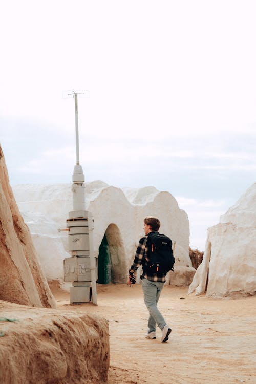 Man with Backpack Walking in Ancient Village