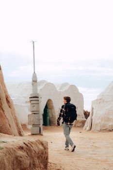 Man with backpack wanderings in unique desert architecture, perfect for adventurous travel themes.