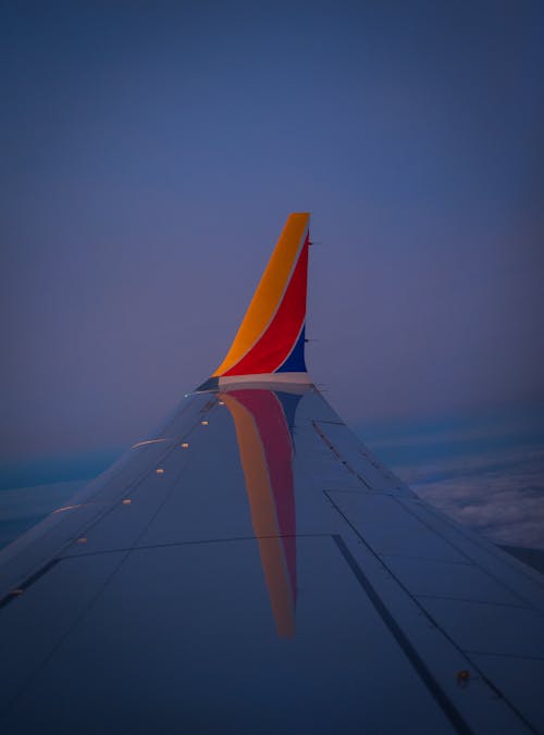 A wing of a plane with the tail of the plane