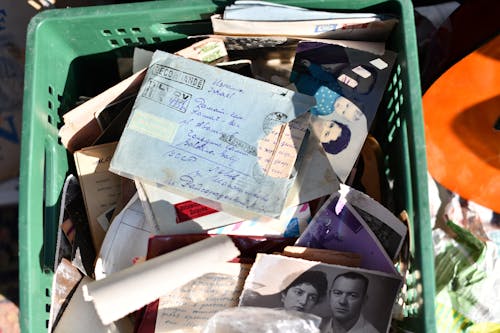 A green basket filled with old photos and papers
