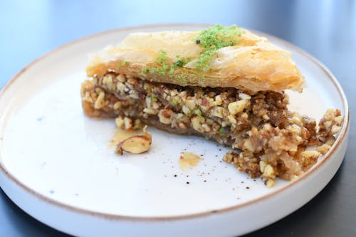 A piece of pie on a plate with nuts and seeds