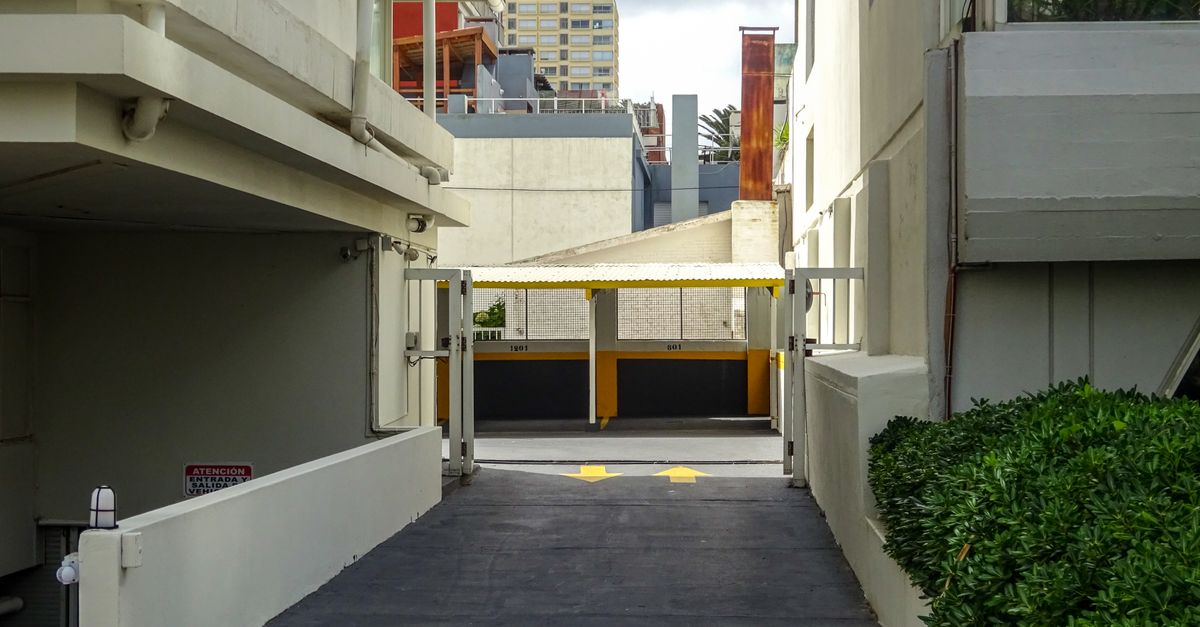 A paved alleyway with directional arrows between buildings in Punta del Este, Uruguay.
