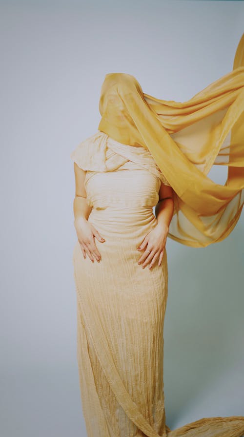 A woman in a yellow dress with a veil