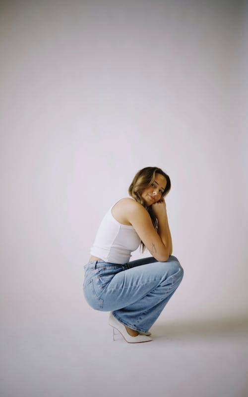 Бесплатное стоковое фото с белый фон, вертикальный выстрел, джинсы