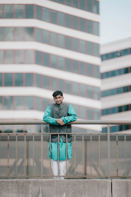 Man Wearing Turquoise Gown in a City 