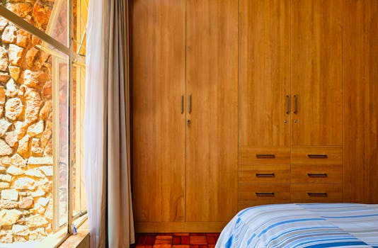 Cozy bedroom interior with a wooden closet and natural stone wall.