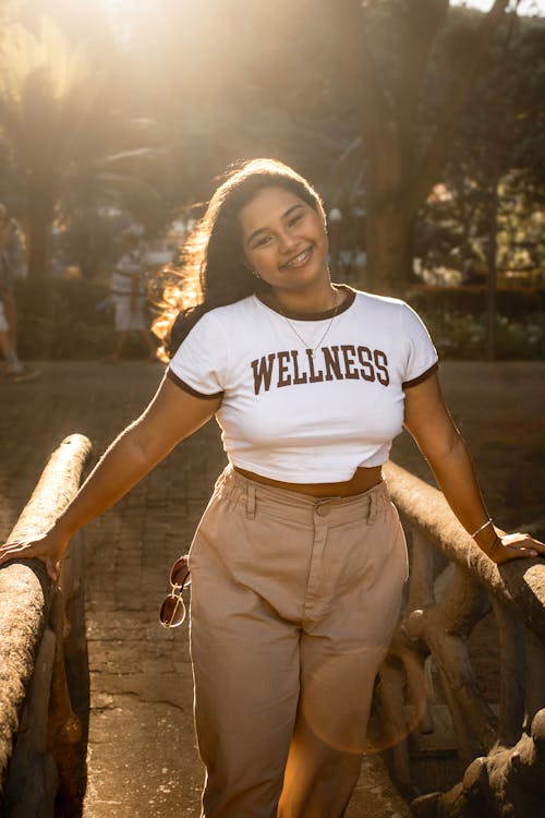 Free A woman posing for a photo in front of a wooden fence Stock Photo