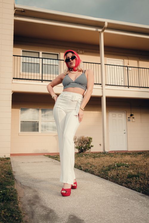 Free Woman with sunglasses and striped top posing confidently outdoors. Stock Photo