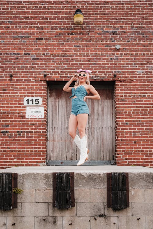 Free A woman in a blue bathing suit standing on a brick wall Stock Photo