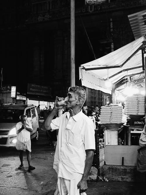 A man standing in front of a store at night