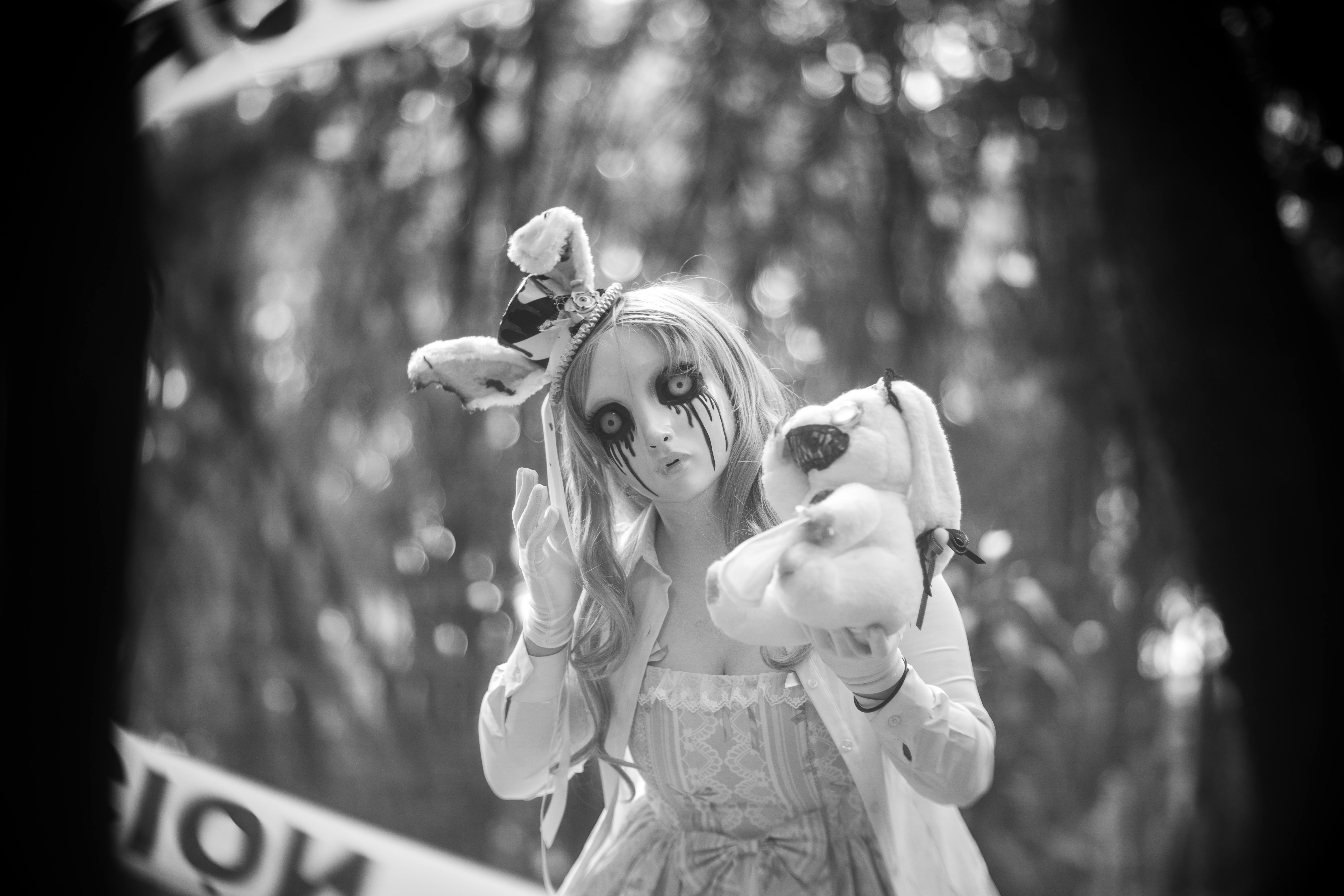 black and white photo of a woman dressed in a scary doll halloween costume