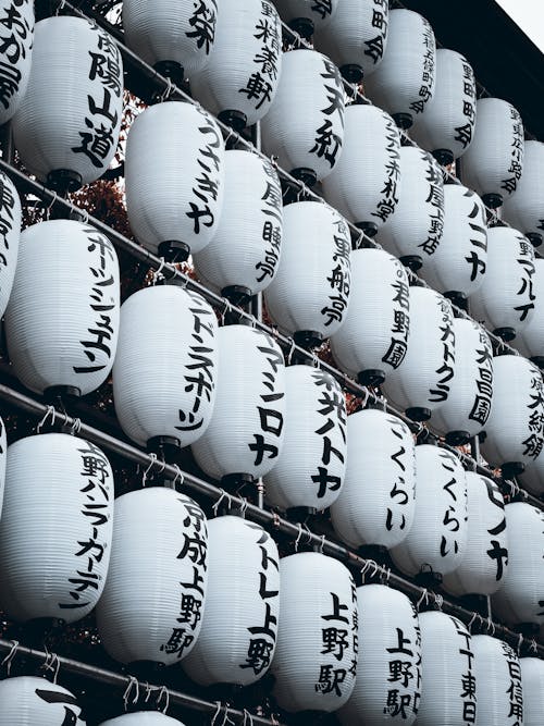 A large number of white lanterns with japanese writing on them