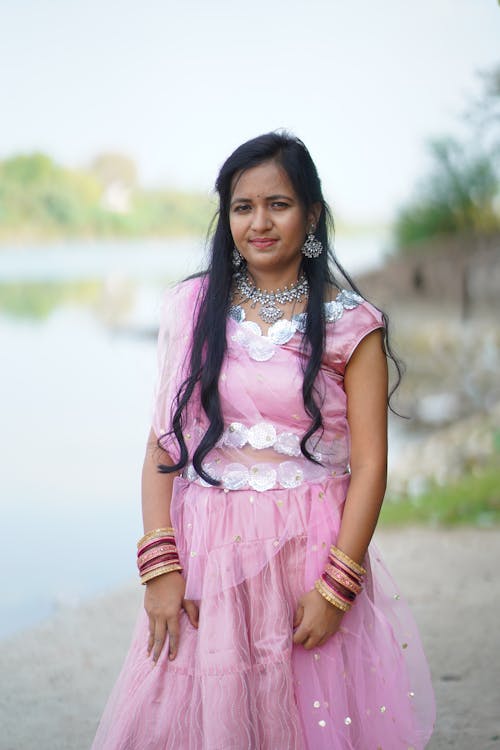 A beautiful indian woman in a pink dress posing for the camera