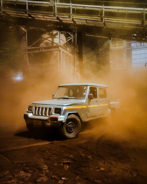 A jeep is driving through a dusty area