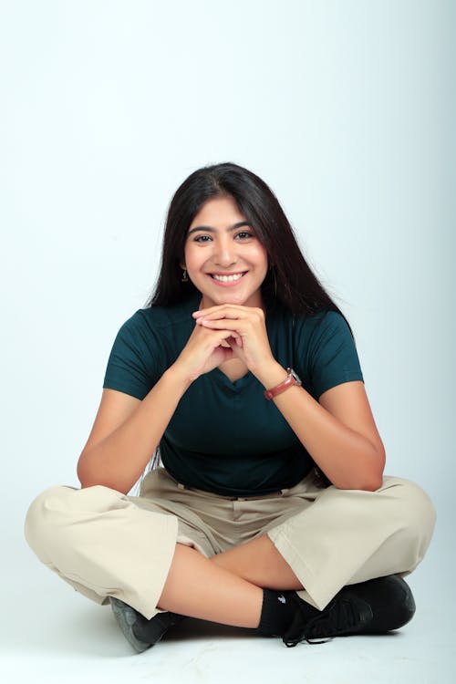 Free A woman sitting on the floor with her hands on her knees Stock Photo
