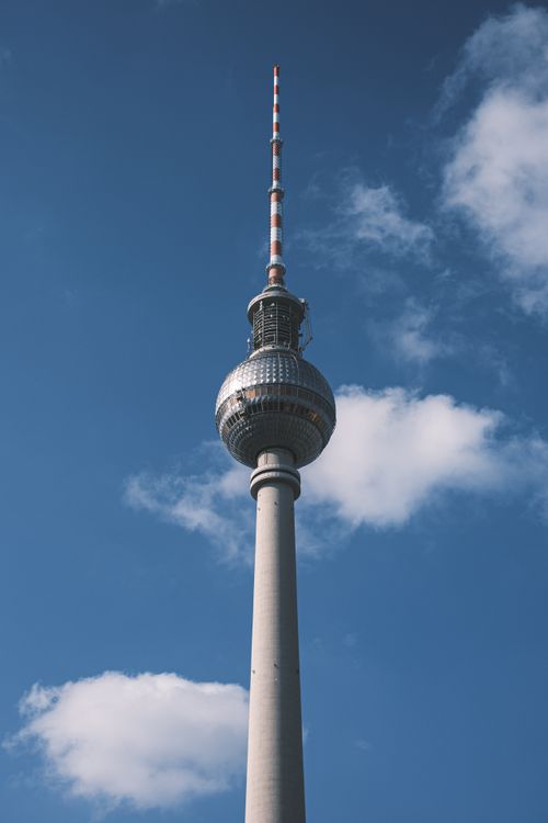 Free Iconic Berlin TV Tower with a clear blue sky as a backdrop on a sunny day. Stock Photo