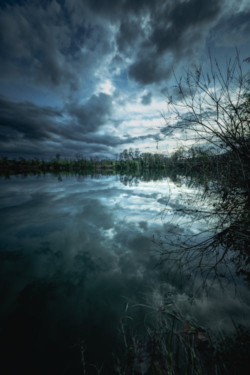 A dark sky with clouds over a lake