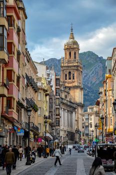 Bustling street scene with a view of the Cathedral in Jaén, Spain, showcasing urban architecture.