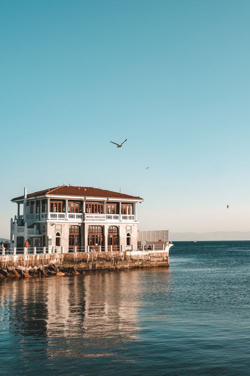 Free Serene view of a pier building in Kadıköy, İstanbul, with calm sea and clear skies. Stock Photo