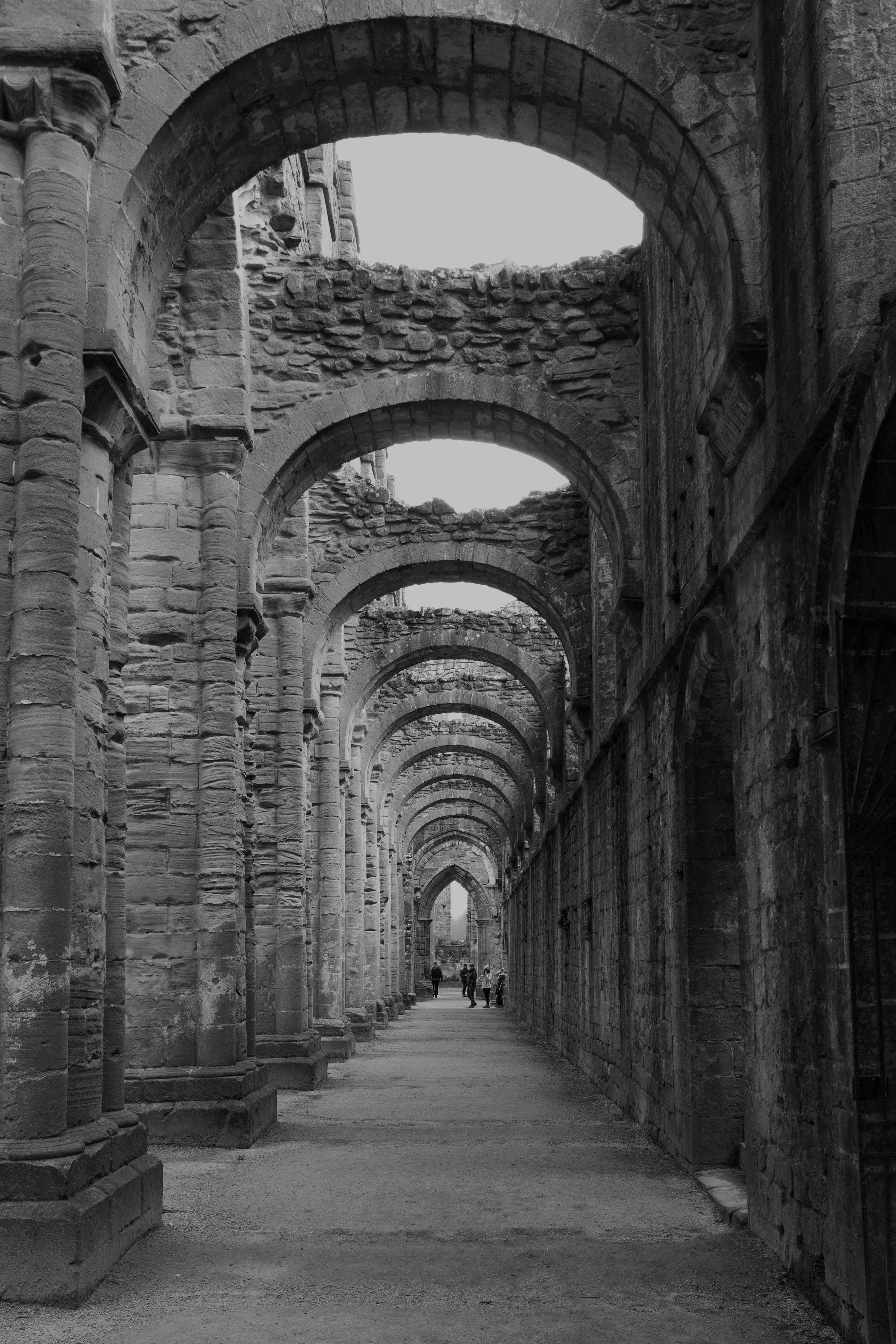 Black and white view of historic arches in Fountains Abbey, England.