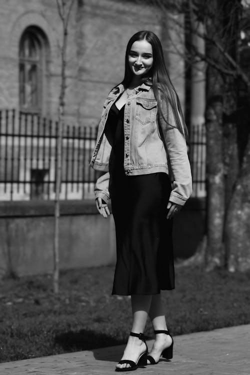 Brunette Woman in Jacket and Black Dress Posing on Sidewalk