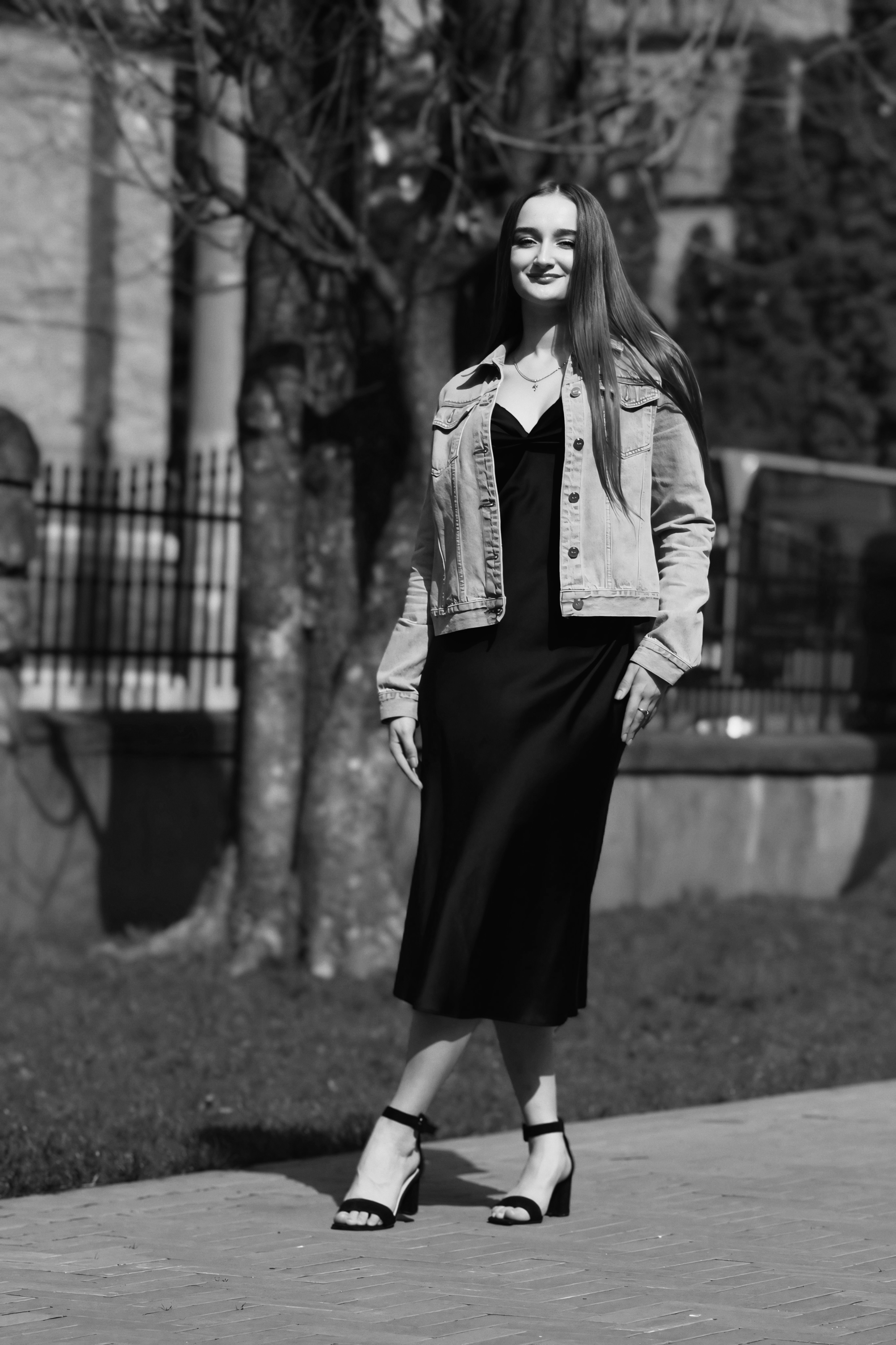 Woman in Denim Jacket and Black Dress Walking on Sidewalk  Free Stock Photo