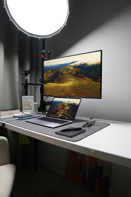 A desk with a laptop and a monitor on it
