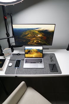 Stylish home office setup featuring a laptop, monitor, smartphone, and tech accessories on a desk.