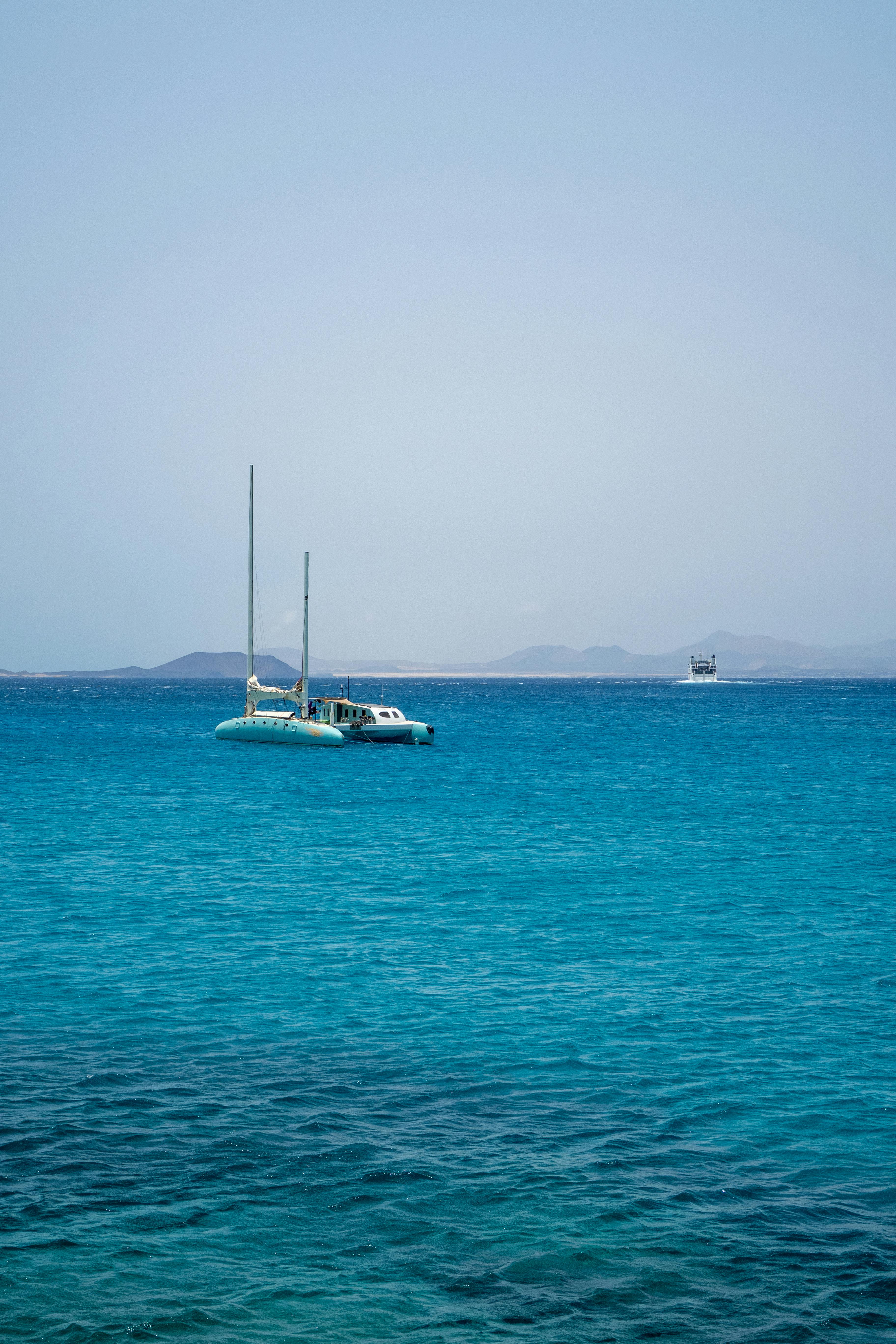 catamaran with lowered sails on the turquoise ocean