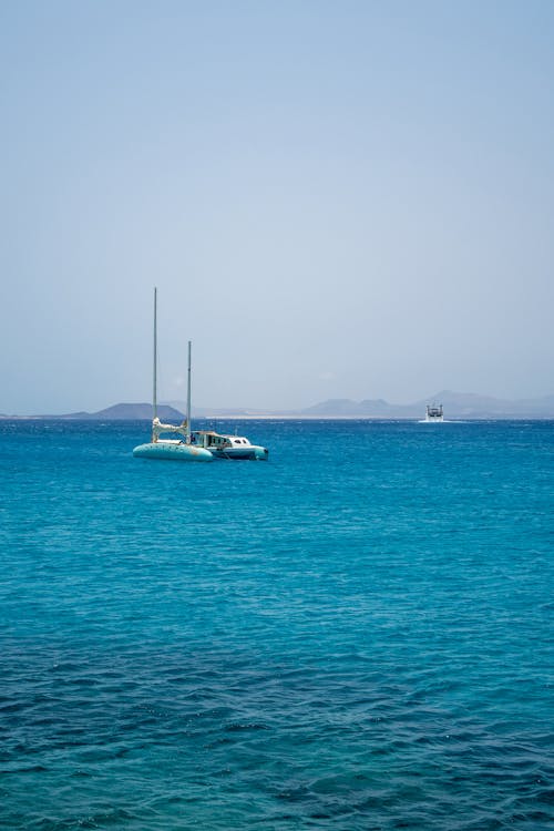 A sailboat is in the blue ocean