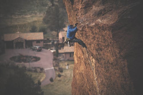 Free Man Rock Climbing on Cliff Stock Photo