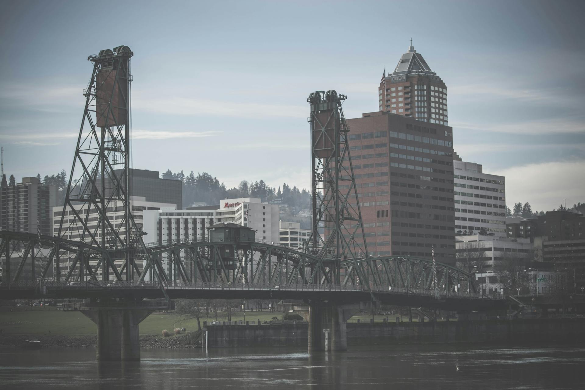 Foggy view of Portland skyscrapers and the iconic Steel Bridge across the Willamette River.