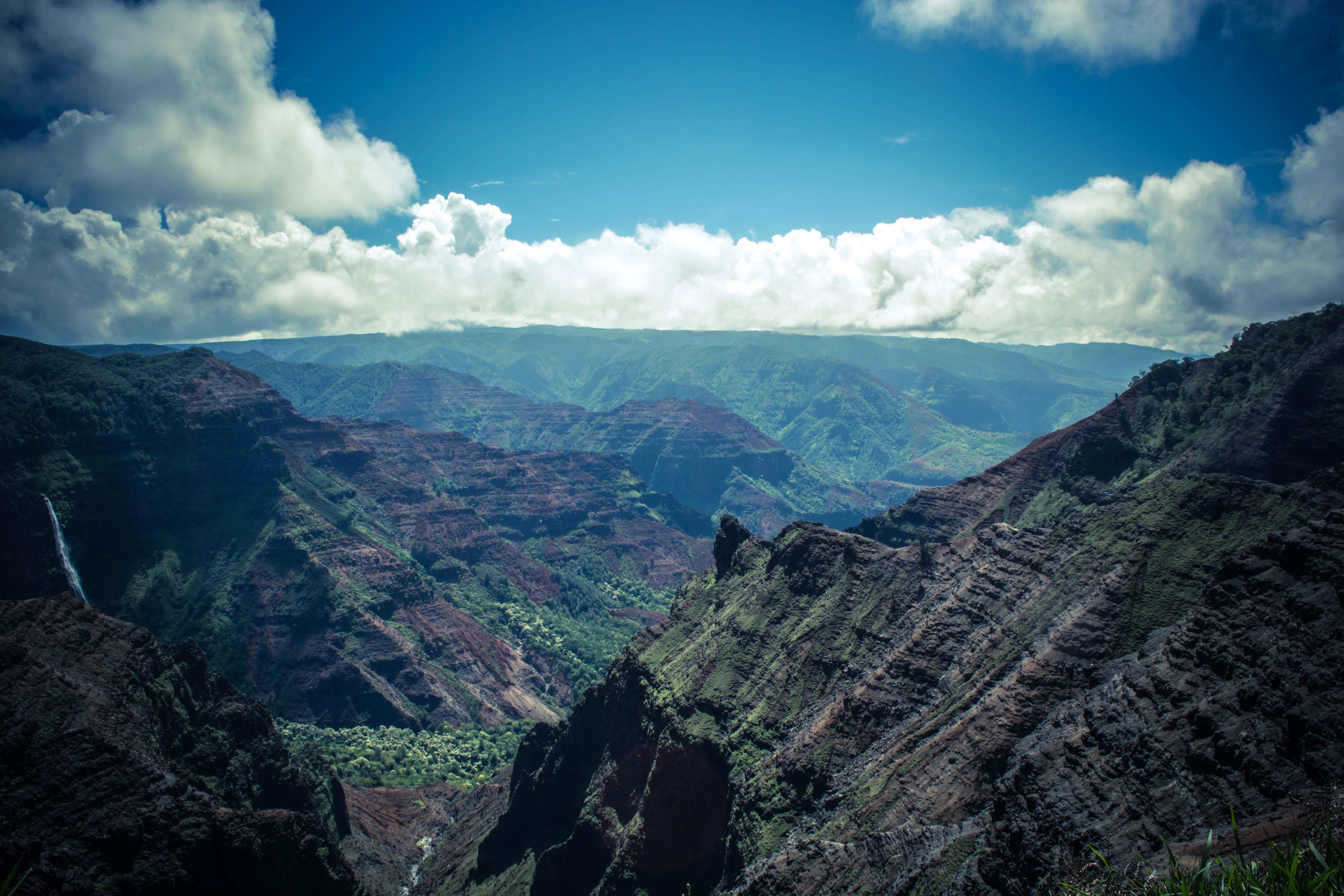 Kauai: Heart of the Island Doors-Off Helicopter Tour - Stunning view of the Waimea Canyon under a blue sky, showcasing vibrant natural beauty and dramatic landscapes.