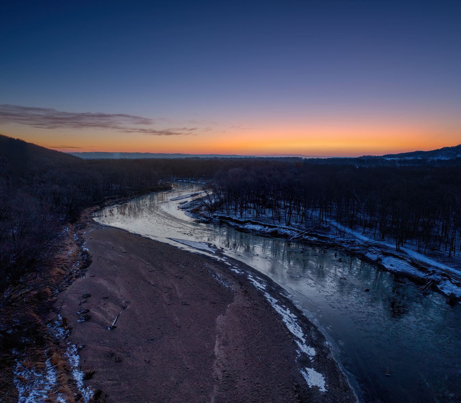 A breathtaking winter sunrise over a meandering river in Minnesota, USA, showcasing a serene snowy landscape.