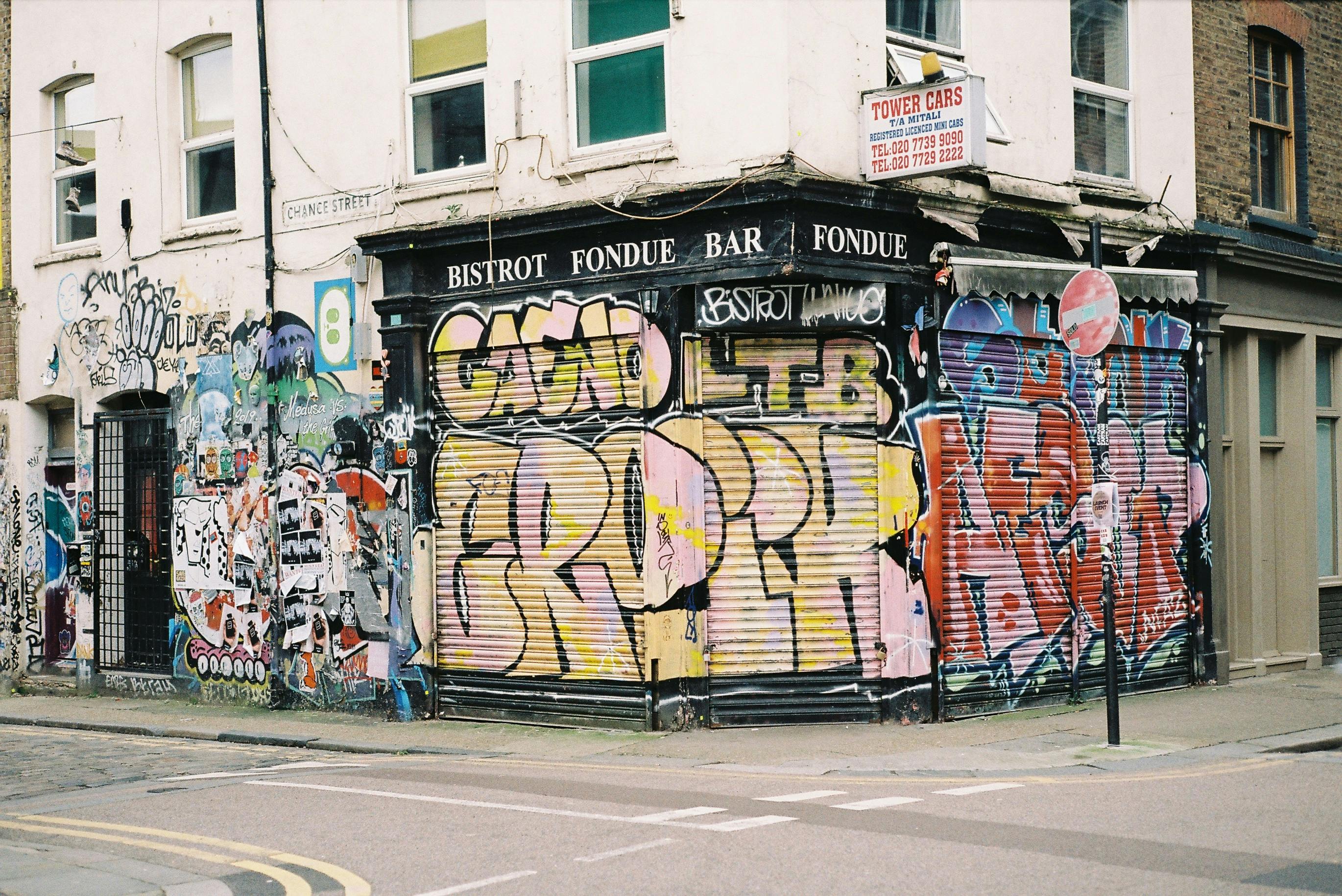Colorful graffiti art on an urban building corner, showcasing vibrant street culture.