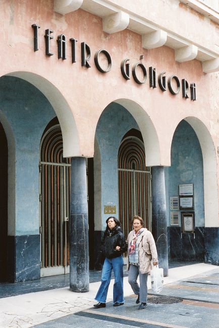 Women walking past the historic Teatro Góngora in Córdoba, Spain.