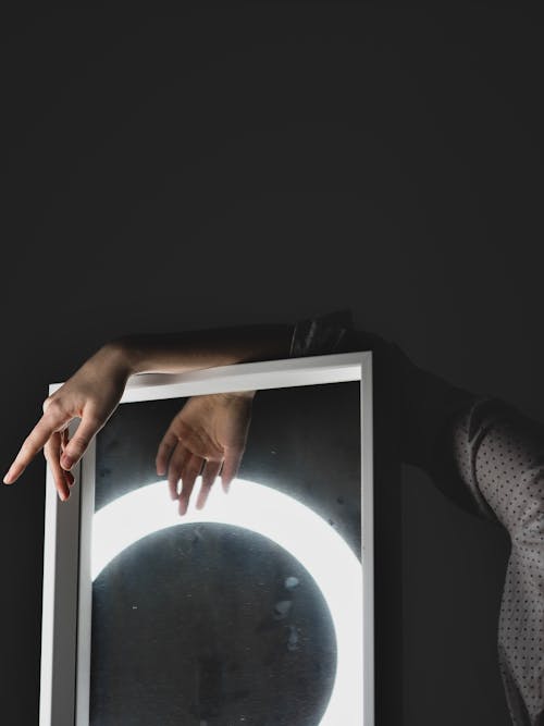 A man holding a light up mirror with a circle in the middle