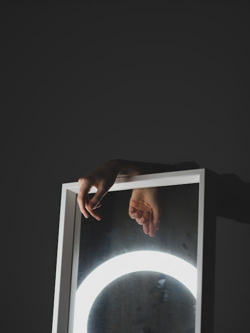 A person holding a mirror with a circle on it