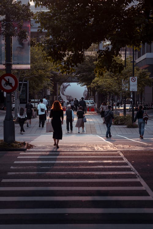 A woman walking across a crosswalk in a city