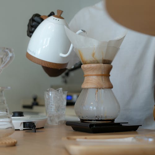 Free A person pouring coffee into a coffee maker Stock Photo