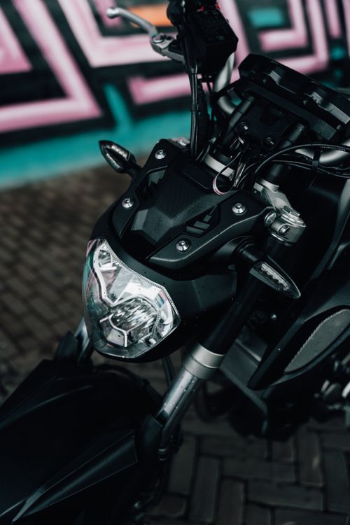 Free Close-up of a black motorcycle headlight with urban graffiti background in Arnhem, Netherlands. Stock Photo