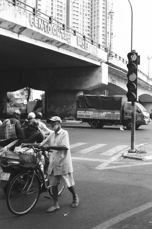 A black and white photo of a man on a bicycle