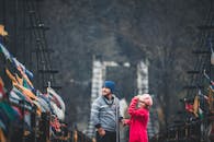 一对年轻夫妇穿着暖和的冬装，手牵手走在马纳利风景秀丽的桥上