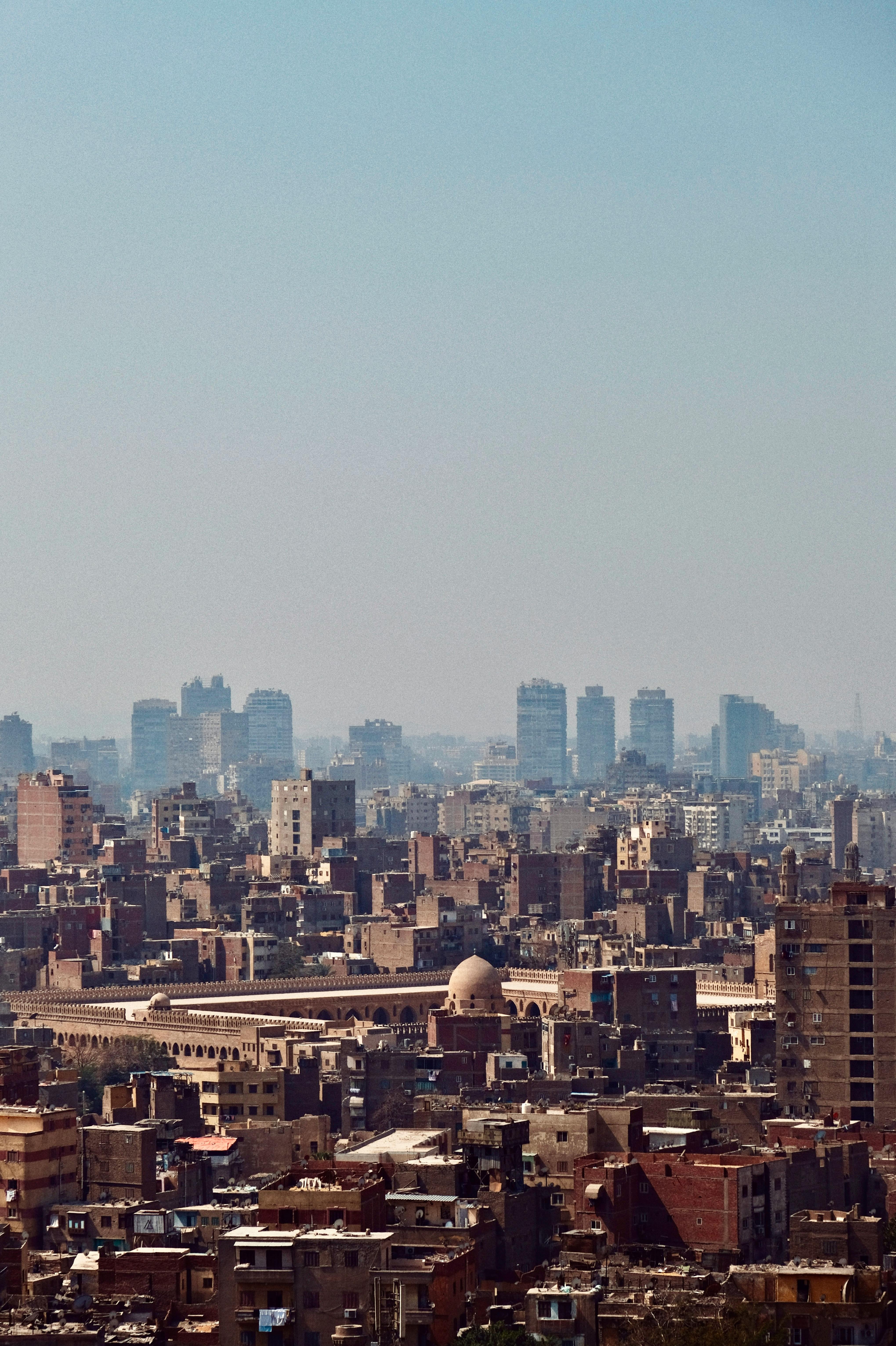 Aerial view of Cairo's urban skyline featuring a historic mosque against the cityscape.